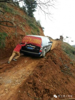  由于地震原因，道路崎嶇，再好的車也要靠人力推才能勉強爬上坡。